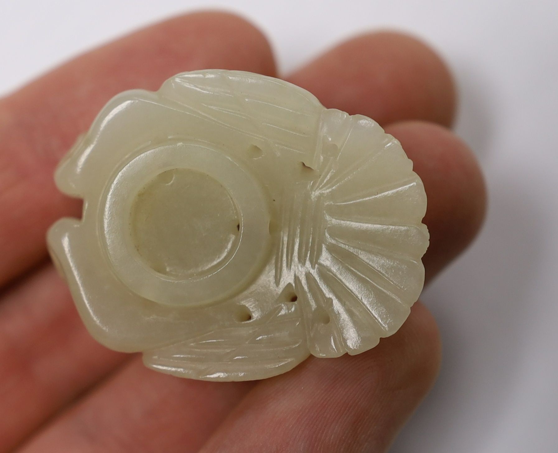 A Chinese pale celadon jade mount carved as a mythical half-man half-bird creature, 18th/19th century, 3.8cm high